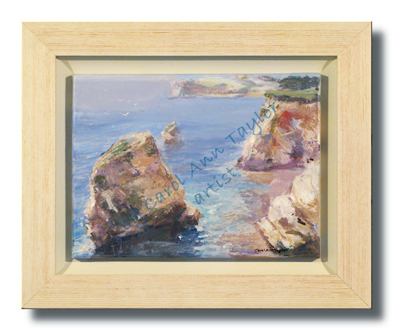 A calm and delightful cliff top sea-view of Freshwater Bay, calm azure sea and rocks on a balmy summer day.